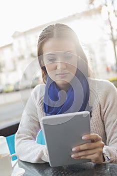 Woman using tablet PC at sidewalk cafe