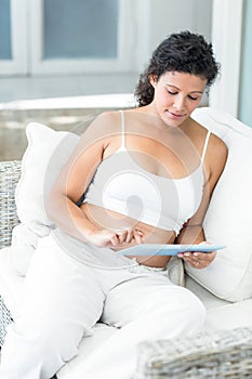 Woman using tablet pc on sofa