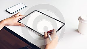 Woman using tablet screen blank and smartphone on the table mock up to promote your products.