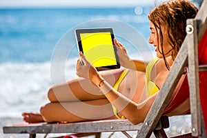 Woman using tablet on the sunbed