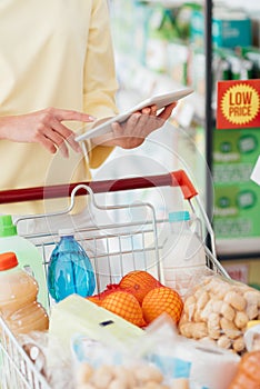 Woman using a tablet at the supermarket