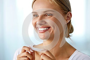 Woman Using Teeth Whitening Strip For Beautiful White Smile