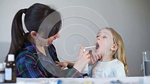 Woman Using Throat Spray for her Daughter
