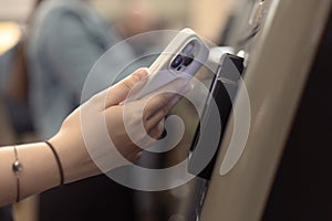 Woman using the ticketing system by cellphone with NFC technology