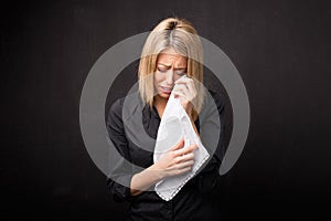 Woman using tissue to wipe her tears