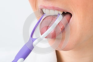 Woman using tongue cleaner