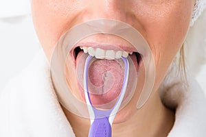Woman using tongue cleaner