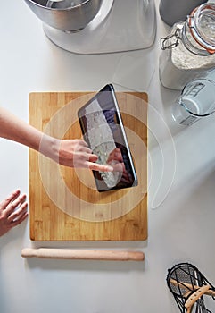 Woman Using Touch Screen on a Top View Digital Tablet In The Kitchen At Home