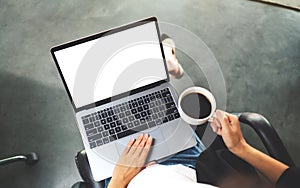 A woman using and touching on laptop computer touchpad with blank white desktop screen while drinking