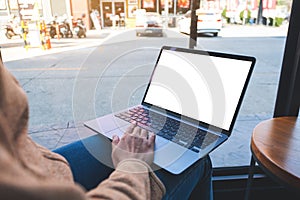 a woman using and touching on laptop touchpad with blank white desktop screen in cafe