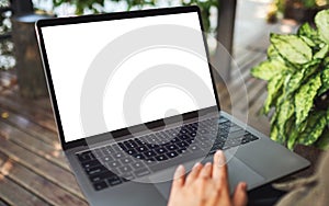 A woman using and touching on laptop touchpad with blank white desktop screen in the outdoors