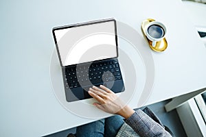 A woman using and touching on tablet touchpad with blank white desktop screen as a computer pc in office