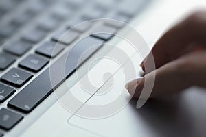 Woman using touchpad on laptop photo