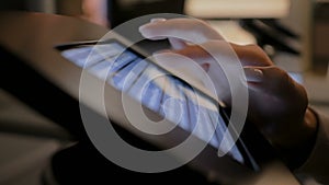 Woman using touchscreen display of floor standing black tablet kiosk: close up