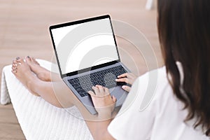 A woman using and typing on laptop computer while sitting at terrece