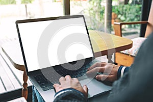 A woman using and typing on laptop keyboard with blank white desktop screen