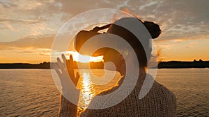 Woman using virtual reality glasses on deck of cruise ship at sunset