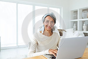 Woman using white laptop on a table.