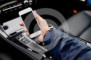 Woman using white smartphone in car.