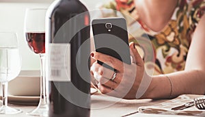 Woman using a wine app at the restaurant