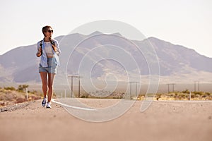 Woman On Vacation Hitchhiking Along Country Road