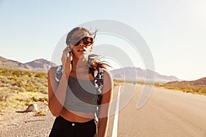 Woman On Vacation Hitchhiking Along Road Using Mobile Phone