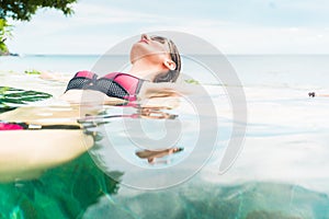 Woman in vacation relaxing swimming in pool