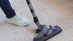 Woman with vacuum cleaner cleaning carpet at home