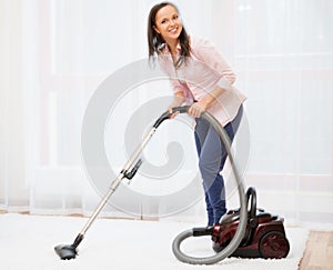 Woman vacuum cleaning carpet