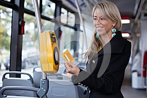 Woman validating electronic ticket in public transport