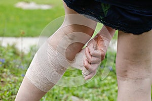 Woman with varicose veins applying compression bandage