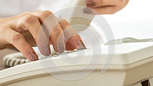 Woman with varnished nails dialling on a phone