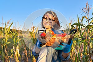 Woman in vegetable garden with freshly picked ripe tomatoes in basket