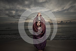 Woman with a veil on the beach