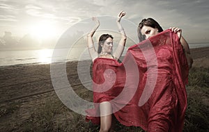 Woman with a veil dancing on the beach