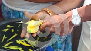 Woman vendor slicing mangos with knife for selling on her stand in Kandy, Sri Lanka