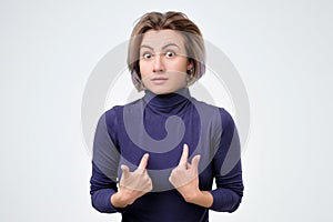 Woman verbally defending herself, having perplexed expression photo
