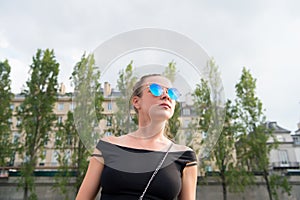 Woman in vest in paris, france. Sensual woman wear sunglasses on cityscape. Wanderlust or vacation and travelling concept. Su