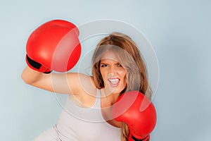 Woman in vest wearing red boxing gloves