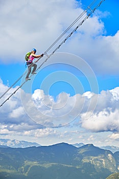 Woman on via ferrata Donnerkogel Intersport Klettersteig in the Austrian Alps, near Gosau. Stairway to Heaven concept