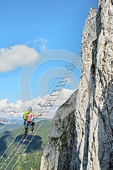 Woman on via ferrata Intersport Klettersteig in Donnerkogel mountains, Austria
