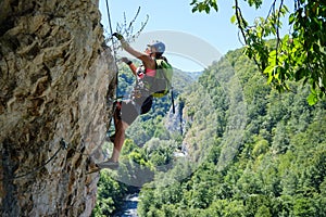 Woman on via ferrata at Suncuius, Bihor county, Romania, on a bright sunny day, with Crisul Repede defile below her