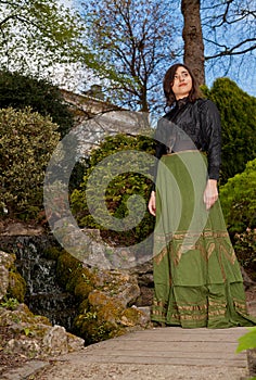 Woman in Victorian dress in the park with waterfall