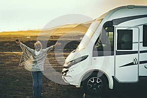 Woman viewed from back enjoy happy her destination in campe van life travel. Back view of female people opening arms and enjoy photo