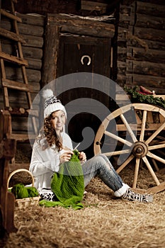 Woman in the village barn with knitting in hand