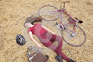 woman with vintage bike , backbag and helmet in hay