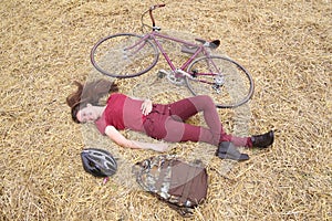 Woman with vintage bike , backbag and helmet in hay