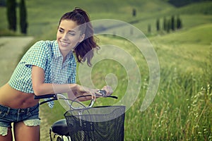 Woman with vintage bike outdoor, summer Tuscany