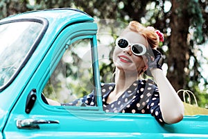 Woman in vintage clothes is driving old car after shopping.