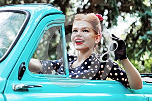 Woman in vintage clothes is driving old car after shopping.